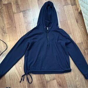 Cropped navy blue hoodie with drawstrings on the side.